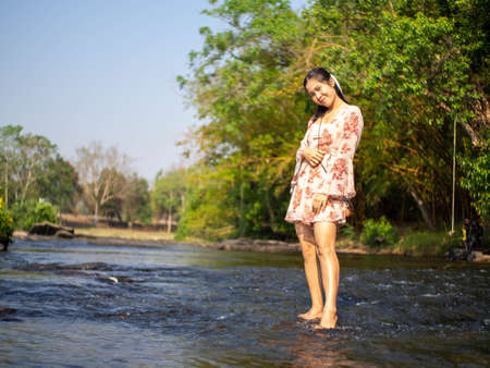 Woman on a wooden swing and a riverの写真素材