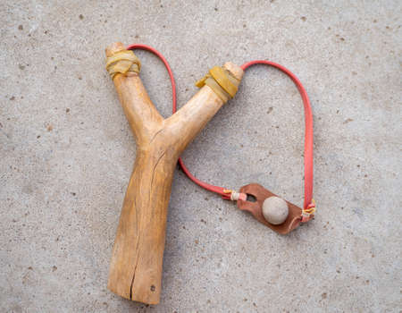A catapult made of wood and a ball of clay.の写真素材