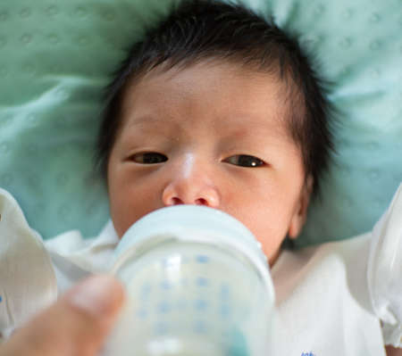 baby suckling from a feeding bottleの写真素材