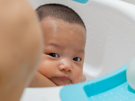 Baby Asian and nationality Thai is bathing in a white basinの写真素材