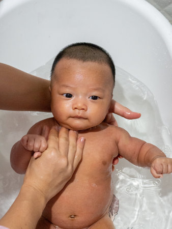Baby Asian and nationality Thai is bathing in a white basin