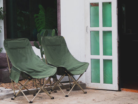 Camping chairs and white houseの写真素材