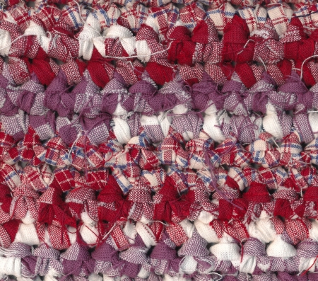 Closeup of crochet rag rug in red, white and purple shadesの写真素材