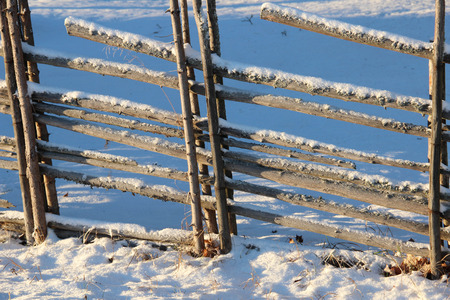 Old Swedish wooden fence in winterの写真素材