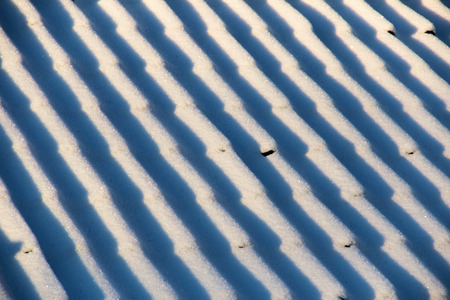 Closeup of snowy rooftop a sunny winter dayの写真素材