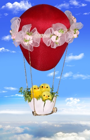 Three Easter chickens on a balloon soaring in the sky. Background for an Easter card with a place for your text. Handiwork.の写真素材