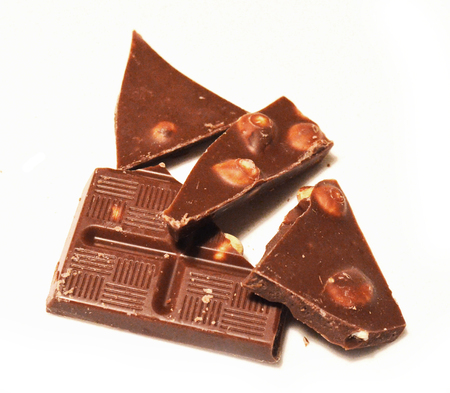 Heap of broken chocolate hazelnut pieces on white backgroundの写真素材