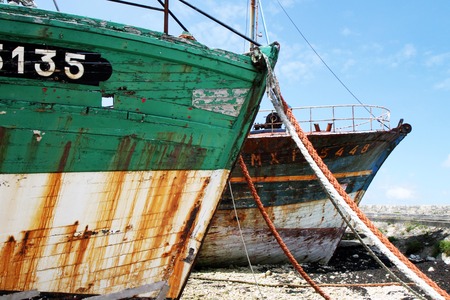 Abandoned ship rusty ship worn old at low tideの写真素材
