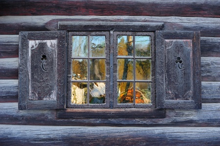 Window of a traditional Norwegian hut with beautiful reflectionの写真素材