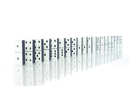 Row of dominoes with reflection on whiteの写真素材
