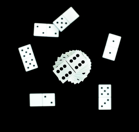 Dominoes scattered on black background