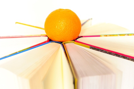 Circle of books and an orangeの写真素材