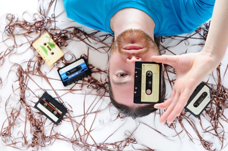 Young man among old tapesの写真素材