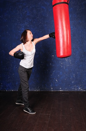 Boxer girl hitting a punchbag の写真素材