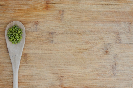 Organic vegetarian food background with mung beans in a wooden tablespoonの写真素材