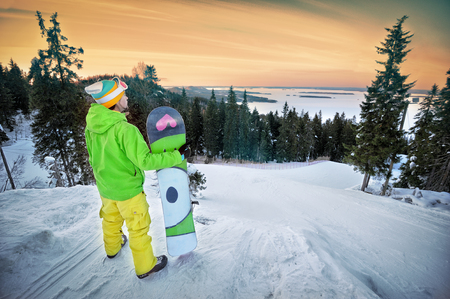 Male snowboarder against panoramic winter landscape backgroundの写真素材