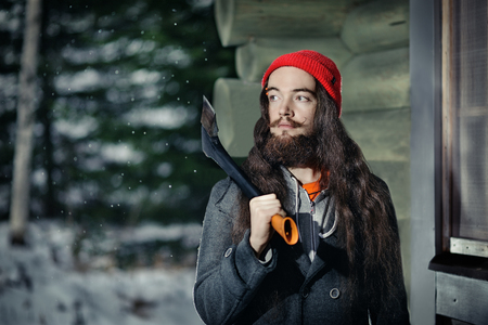 Bearded lumberjack near his hut in a winter forestの写真素材