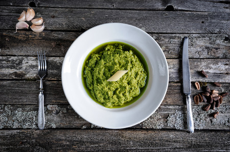Fresh pesto sauce and pasta penne on vintage wooden background
