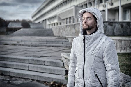Handsome bearded man standing against the backdrop of the constructivist building