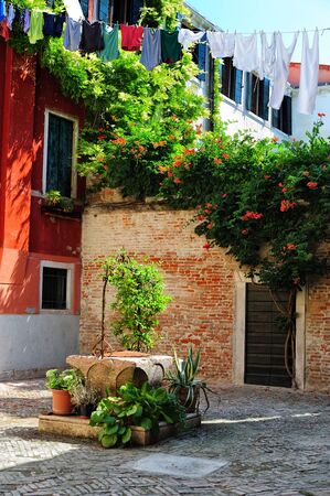 Picturesque view of a medieval courtyard with old well, Venice, Italyの写真素材