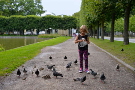 August 2015 - Kadriorg park, Tallinn, Estonia. A girl is feeding the pigeons in the park of Kadriorg, Estoniaのeditorial素材