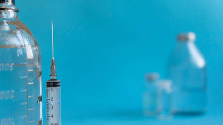 vaccination concept, syringe and glass vial with medicine for injection close-up, copy space