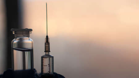 vaccination concept, syringe and glass vial with medicine for injection close-up, soft background...