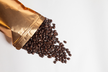 Fresh Coffee beans are poured out of the bag.の写真素材