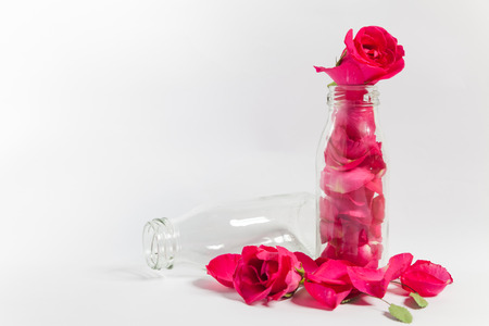 Empty bottles and rose petals On the white backgroundの写真素材