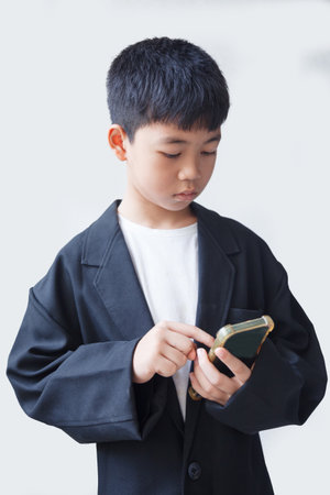 Portrait of asian boy using smart phone on white background.の写真素材