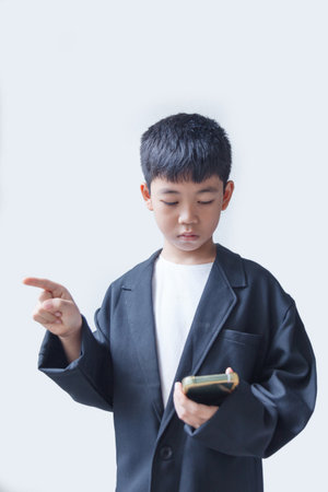 Young asian boy using mobile phone isolated on a white background.の写真素材