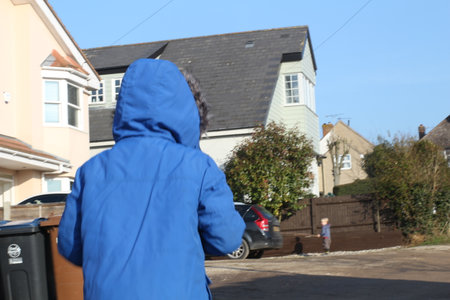 Walking home blue cloth yellow white housesの写真素材