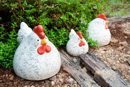 Chicken family cramic on the ground in the gardenの写真素材