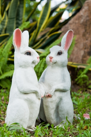The two rabbit dolls in the garden as backgroundの写真素材