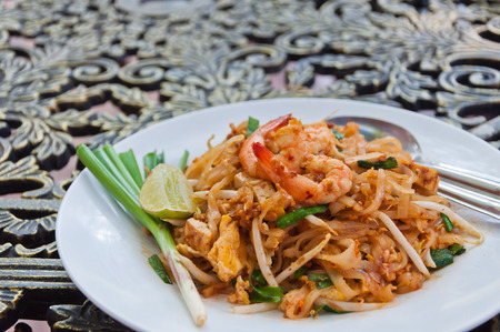 A plate of fried noodle with shrimp in Thai Style on the tableの写真素材