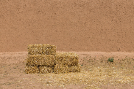 The haystack in front of dried  wall made of soil and straw as afican traditional in Morocco for backgroundの写真素材