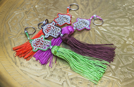 The keyring as fatima hand as souvenir on the brass plate from Fes, Morocco
