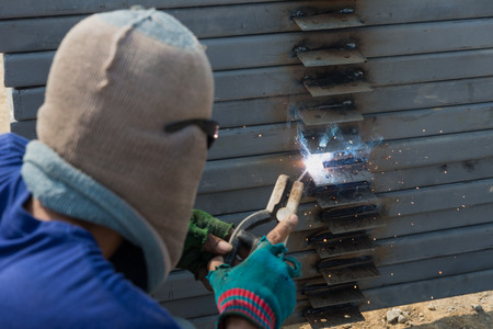 The welder without personal safety protection welds metal