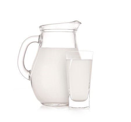 Milk jug with glass over white background の写真素材
