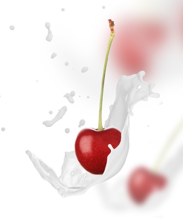 Fresh cherry in milk splash over white background の写真素材
