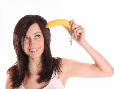 Brunette woman with banana fruit over white の写真素材