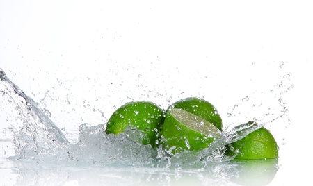 Limes with water splash isolated on white の写真素材