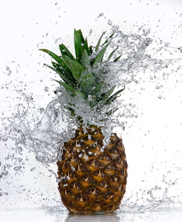 Pineapple with water splash isolated on white の写真素材
