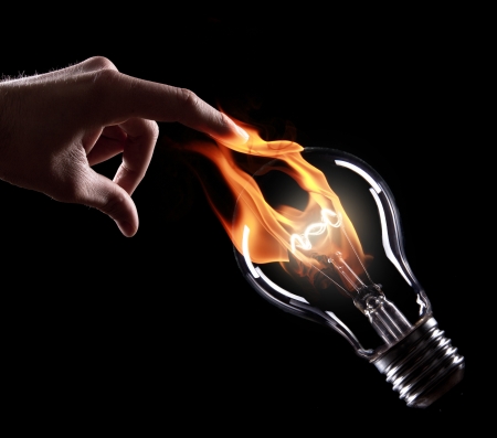 light bulb with fire on black backgroundの写真素材