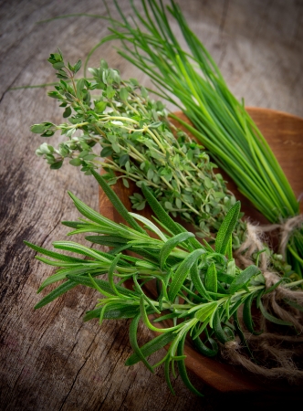 Fresh herbs on wooden tableの写真素材