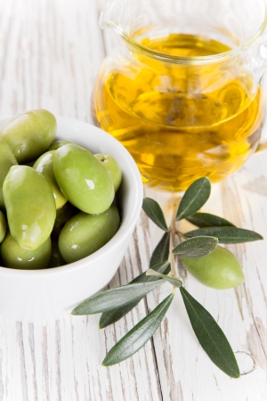 Olives with leaves on a wooden background の写真素材