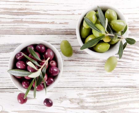 Olives with leaves on a wooden background の写真素材
