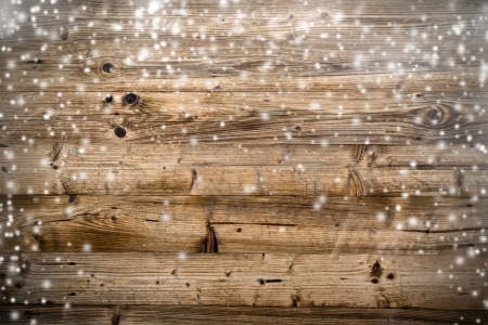 Wooden background with falling snowの写真素材