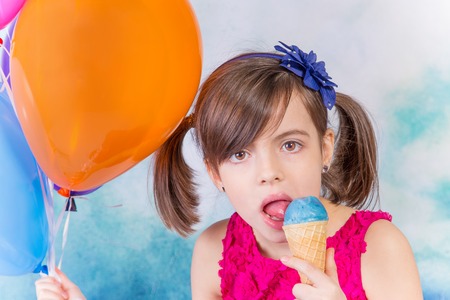 Little cute girl with ice cream and balloons over whiteの写真素材