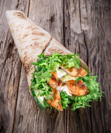 Chicken slices in a Tortilla Wrap with Lettuce on wood の写真素材